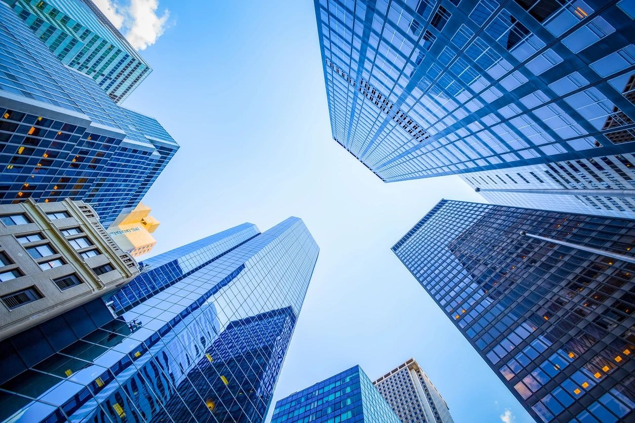 Upward view of modern blue glass skyscrapers framing an open sky